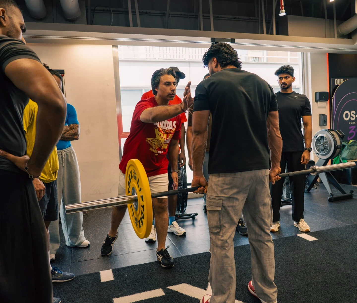 Instructor coaching an exercise professional during a practical barbell session on the FSSA UAE website